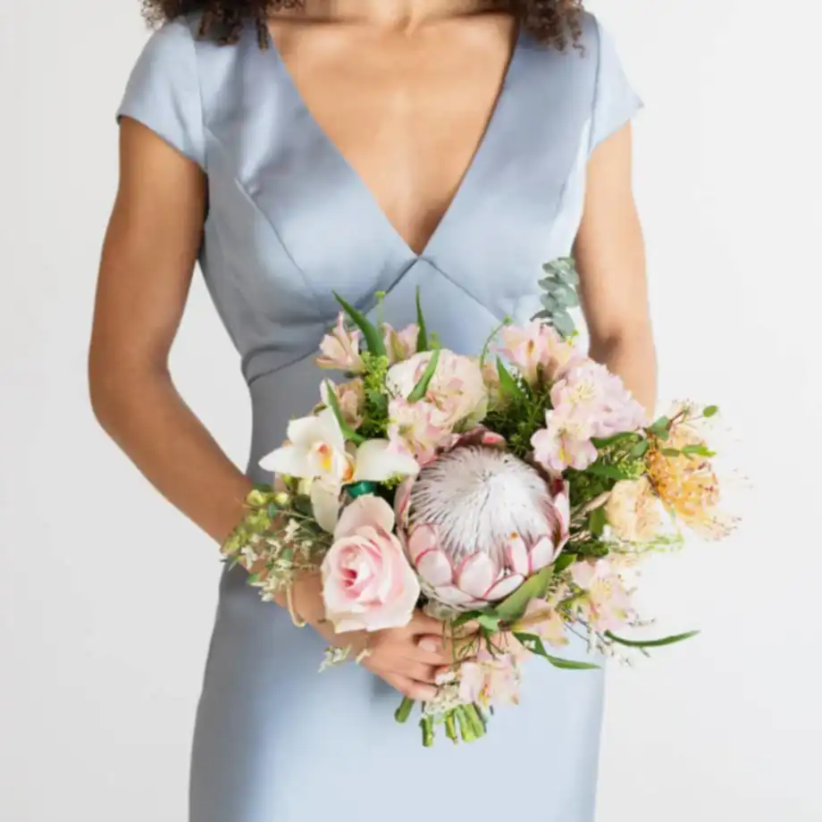 Woman in wedding attire holding a fresh and beautiful bouquet of flowers